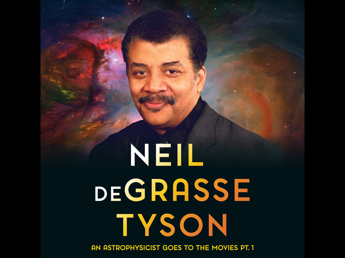Neil deGrasse Tyson stands in front of a Hubble telescope image of the solar galaxy.