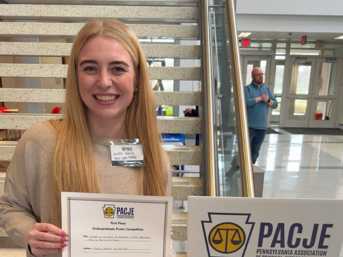 Madison Adamiak holding a certificate for first place in the PACJE Student Poster Competition