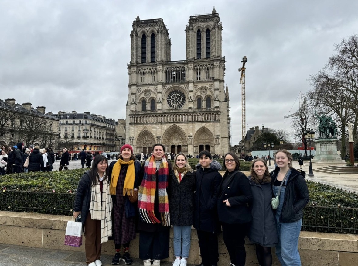 A group of college students gather in front of a cathedral