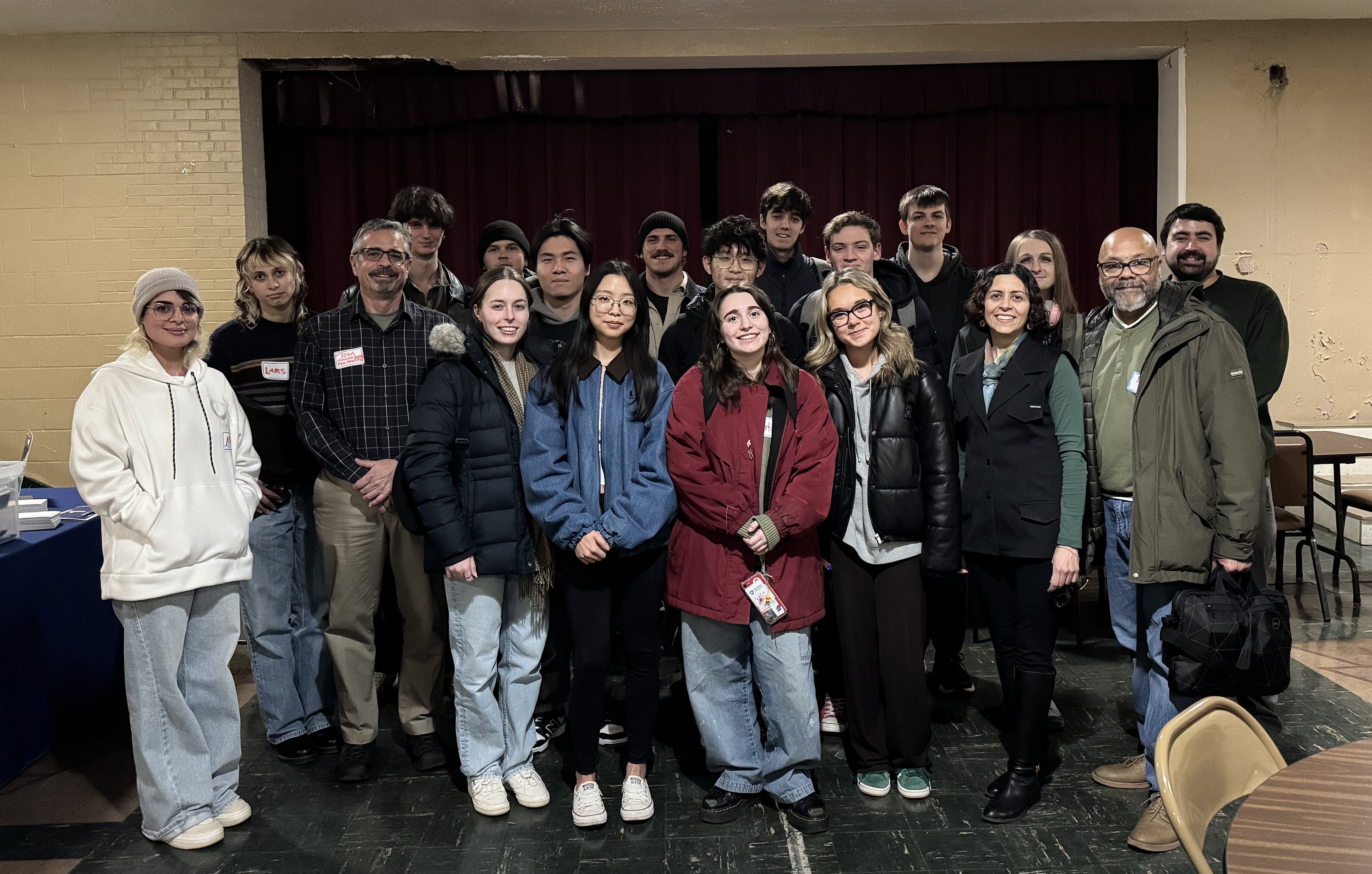 Smiling adults  in winter attire standing together posing for a photo.