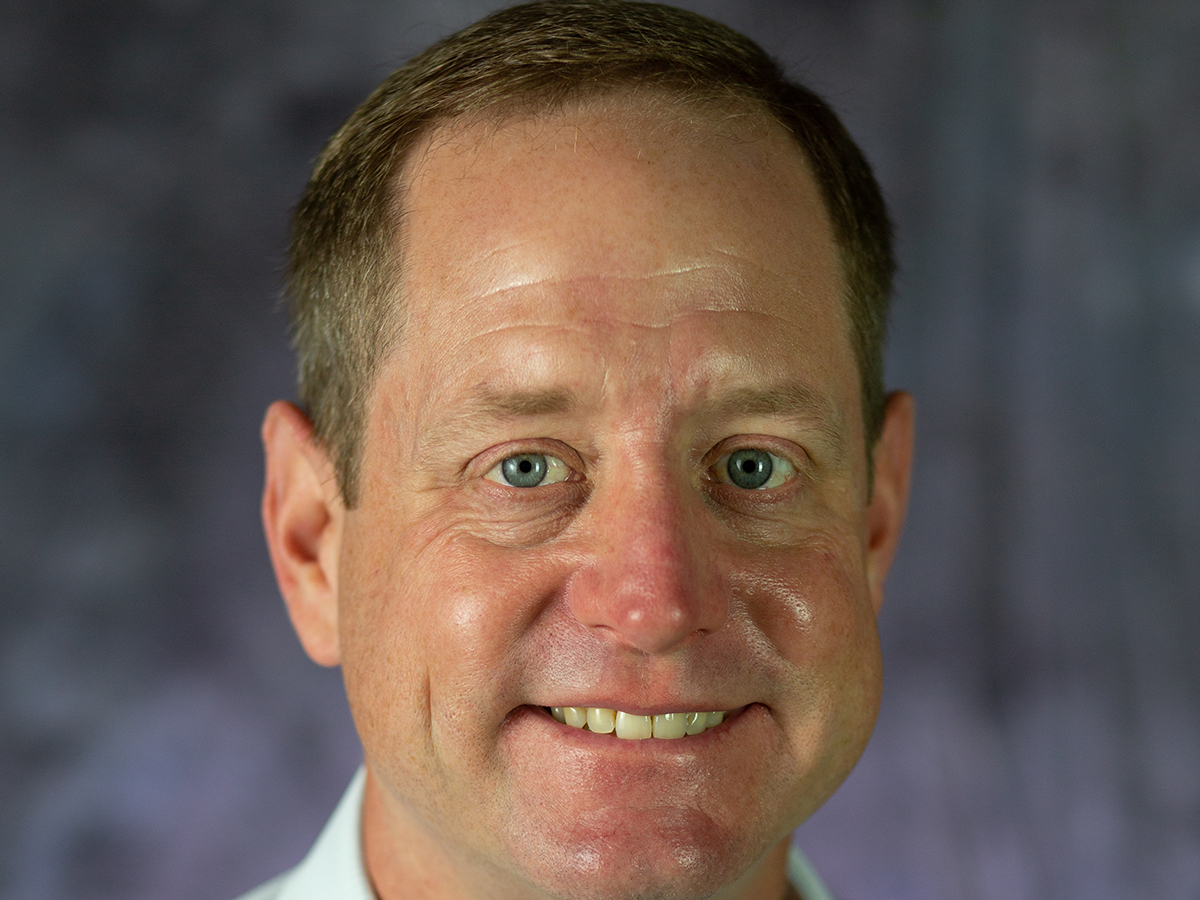 A head shot of a smiling Travis Lesser.