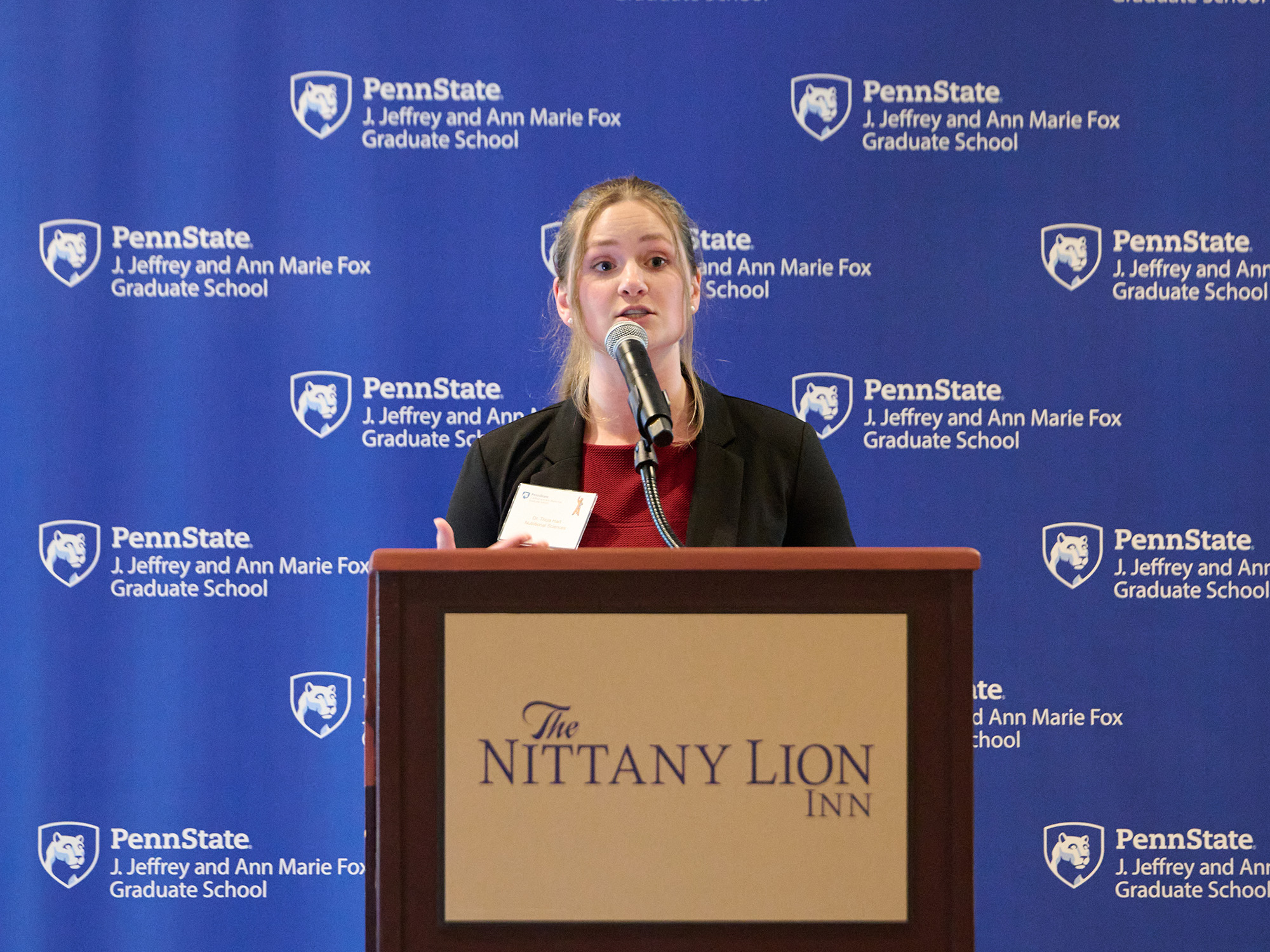 Tricia Hart stands at podium while giving presentation