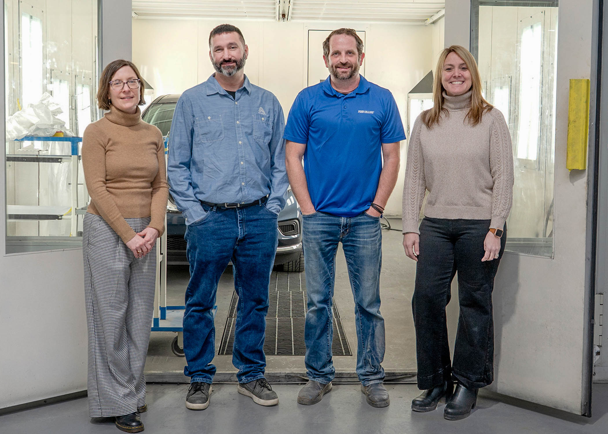 Four smiling people standing in a row.