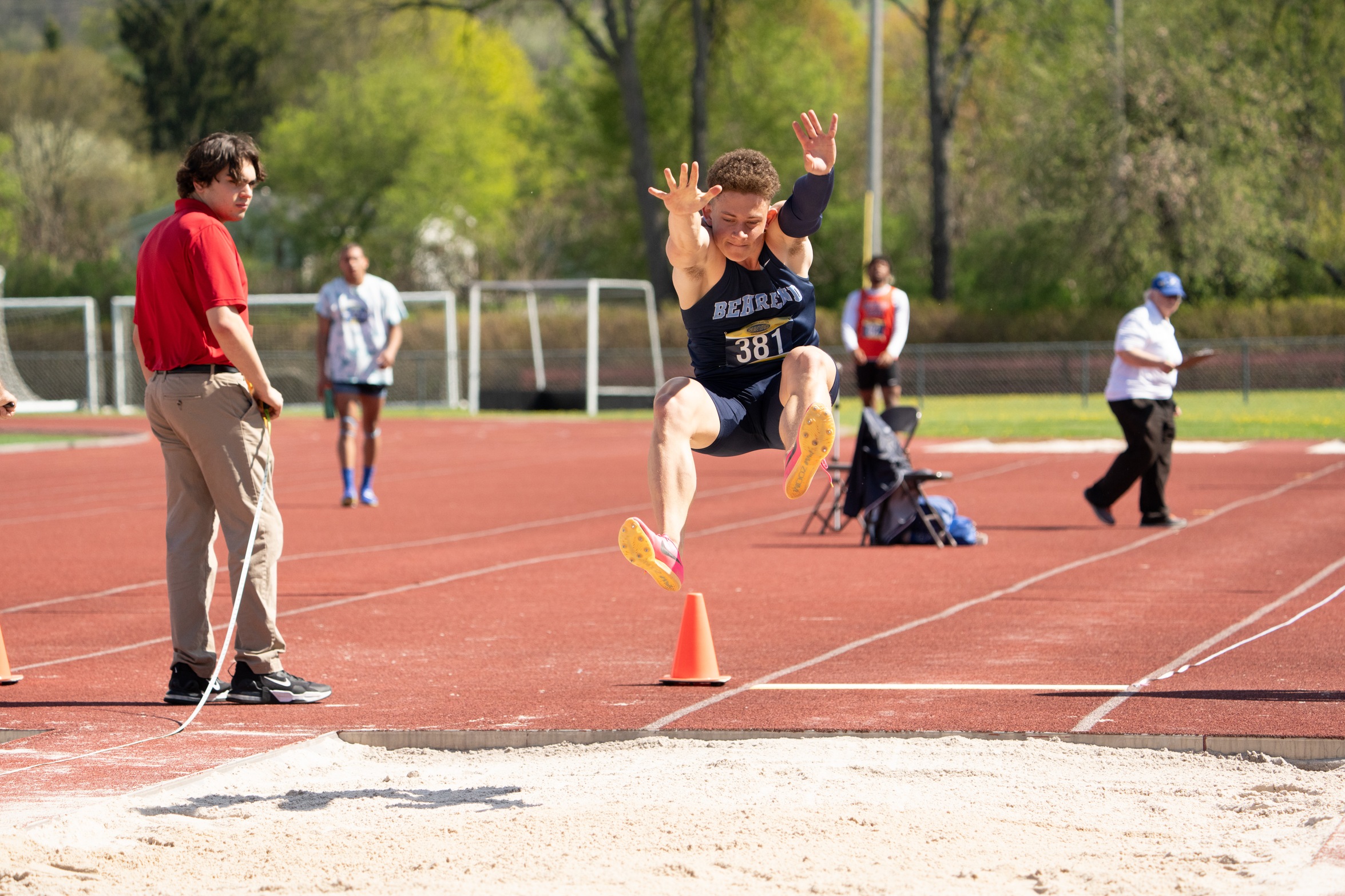 A Penn State Behrend student-athlete competes in the long jump at an outdoor track.