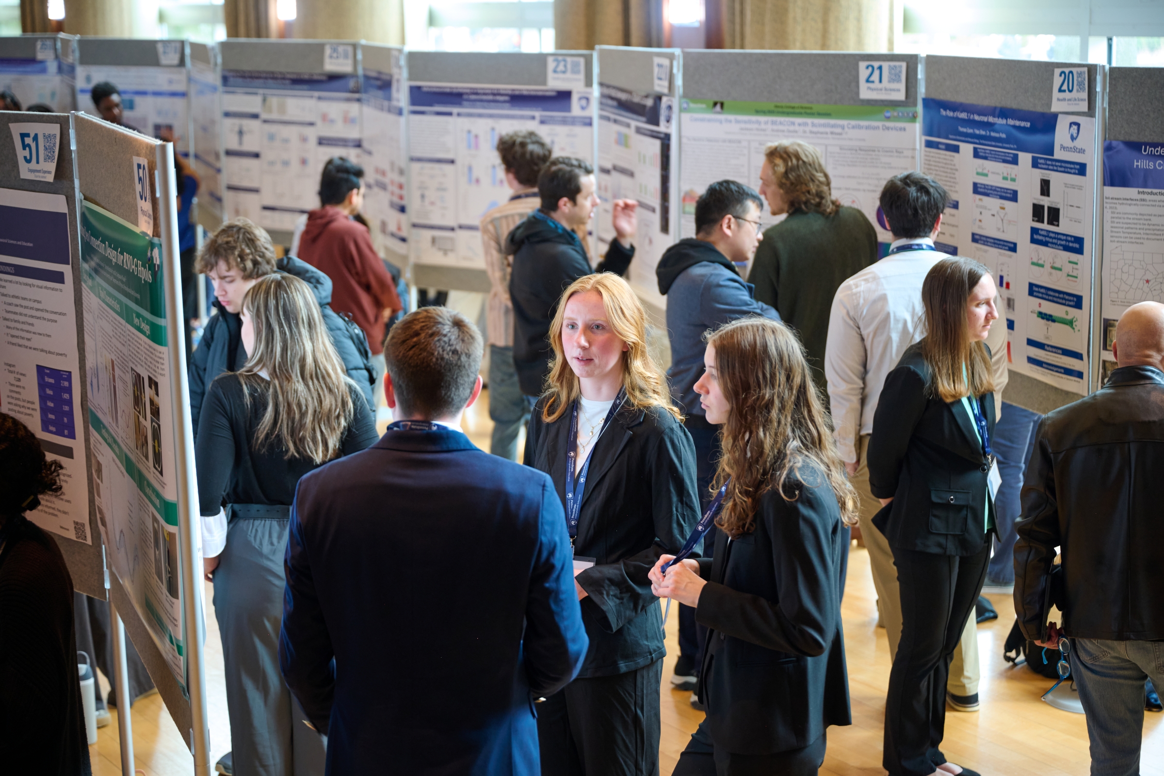 Group of students standing with research posters talking