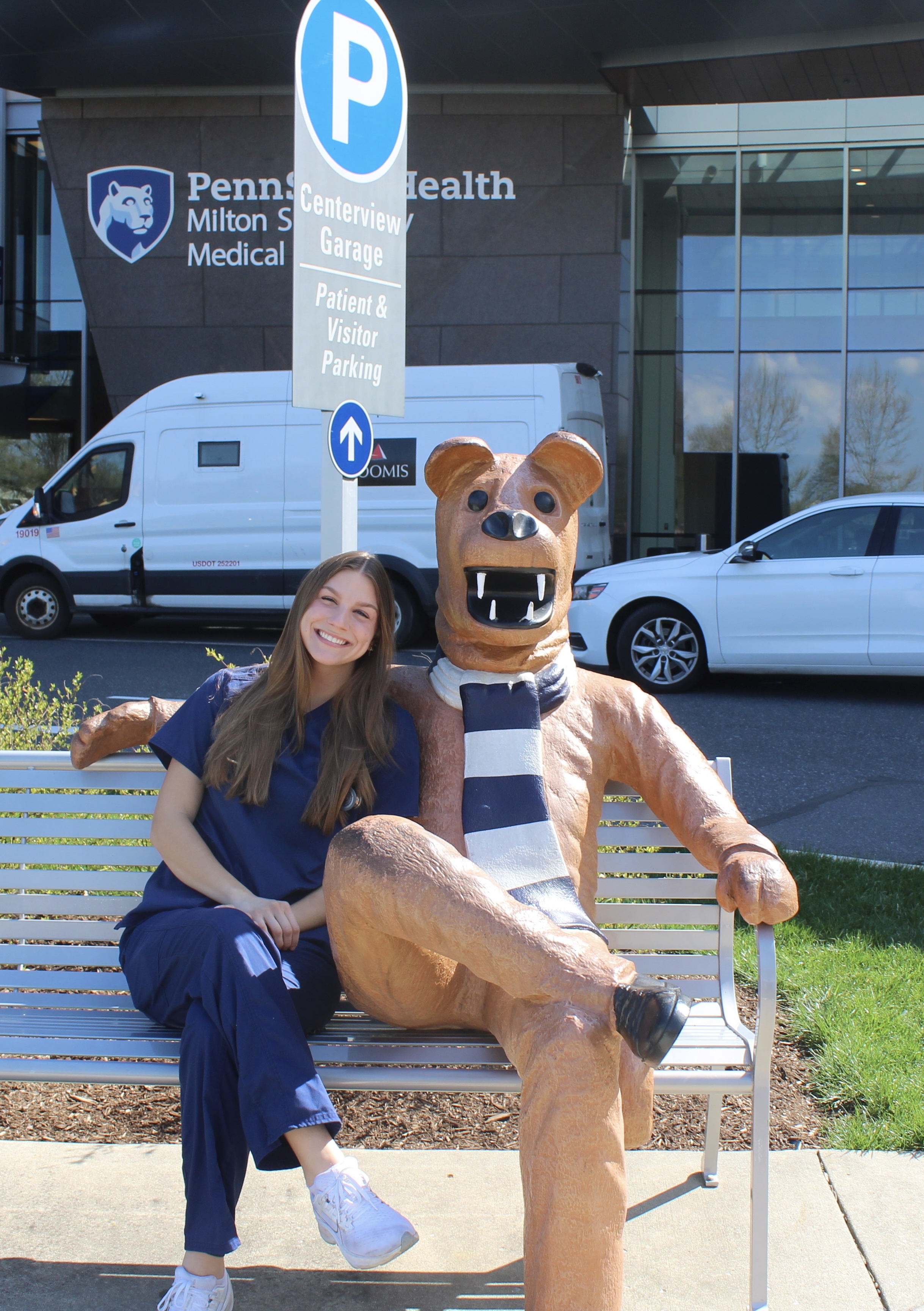 Stephanie Kling, spring 2025 commencement student marshal, sits on a bench with the Nittany Lion