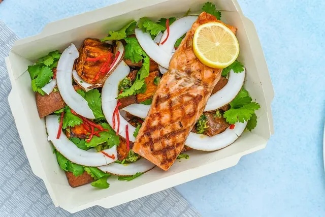 a baking dish with salmon and veggies