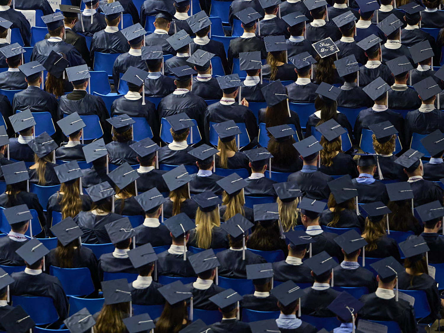 A photo of a sea of blue caps during a commencement ceremony.