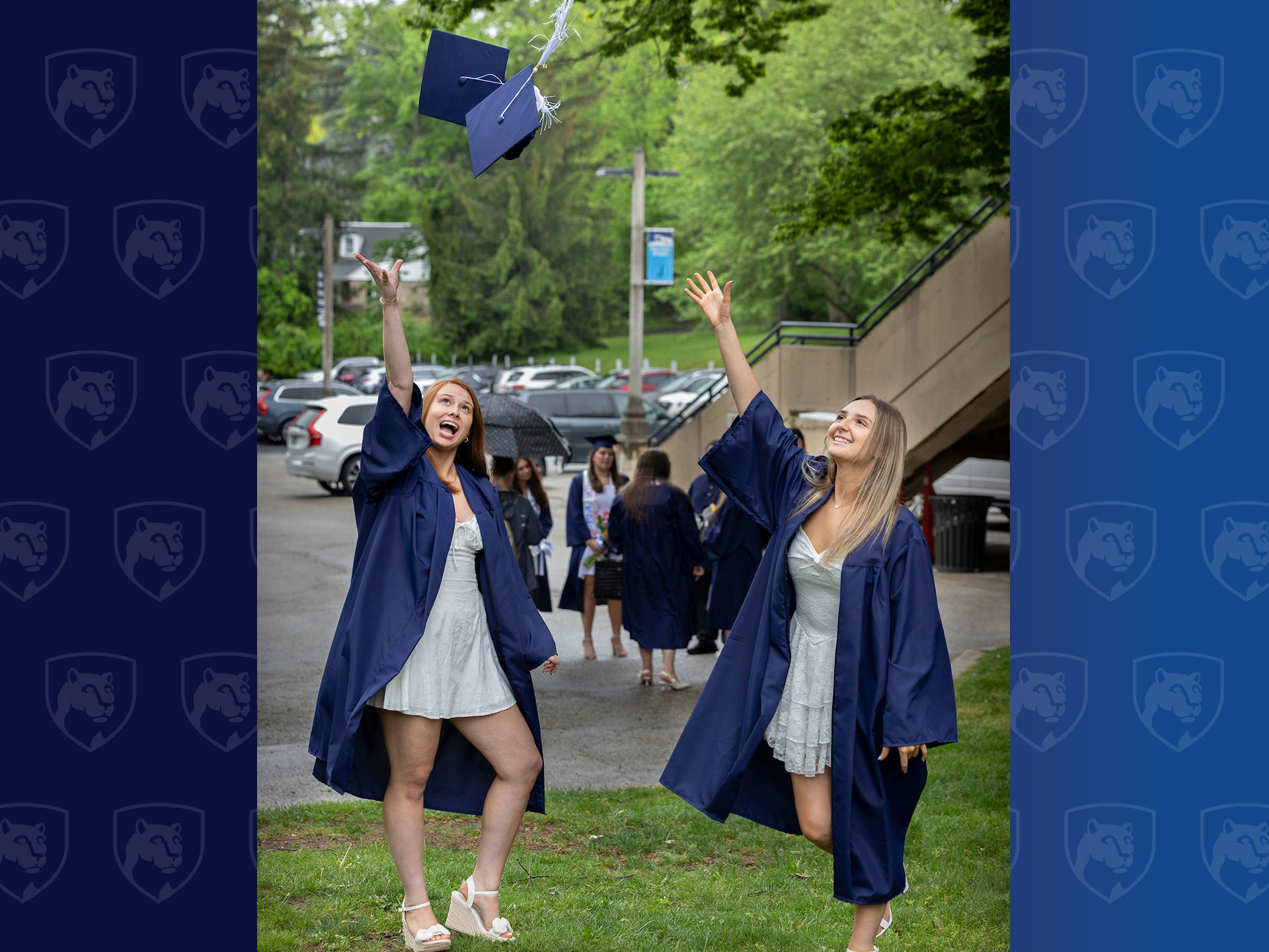 Two women throwing graduation caps in the air