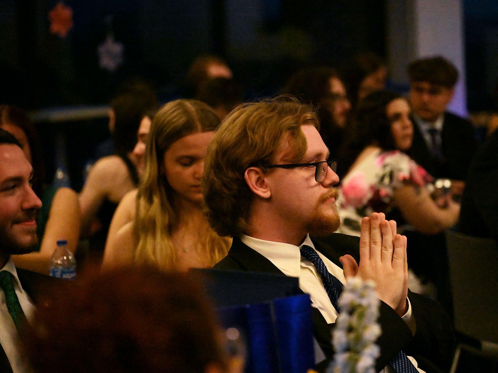Student dressed in suit and tie sitting in audience