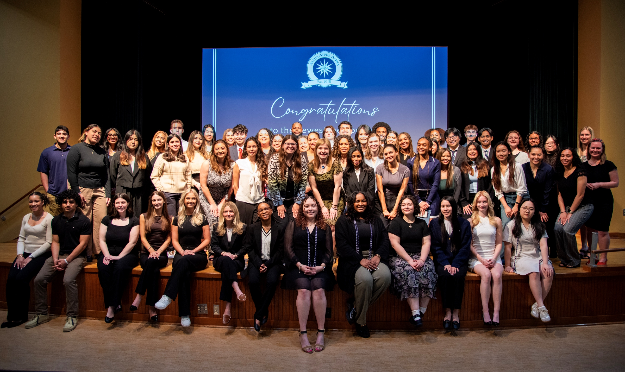 Large group of students posing for a photo on a stage