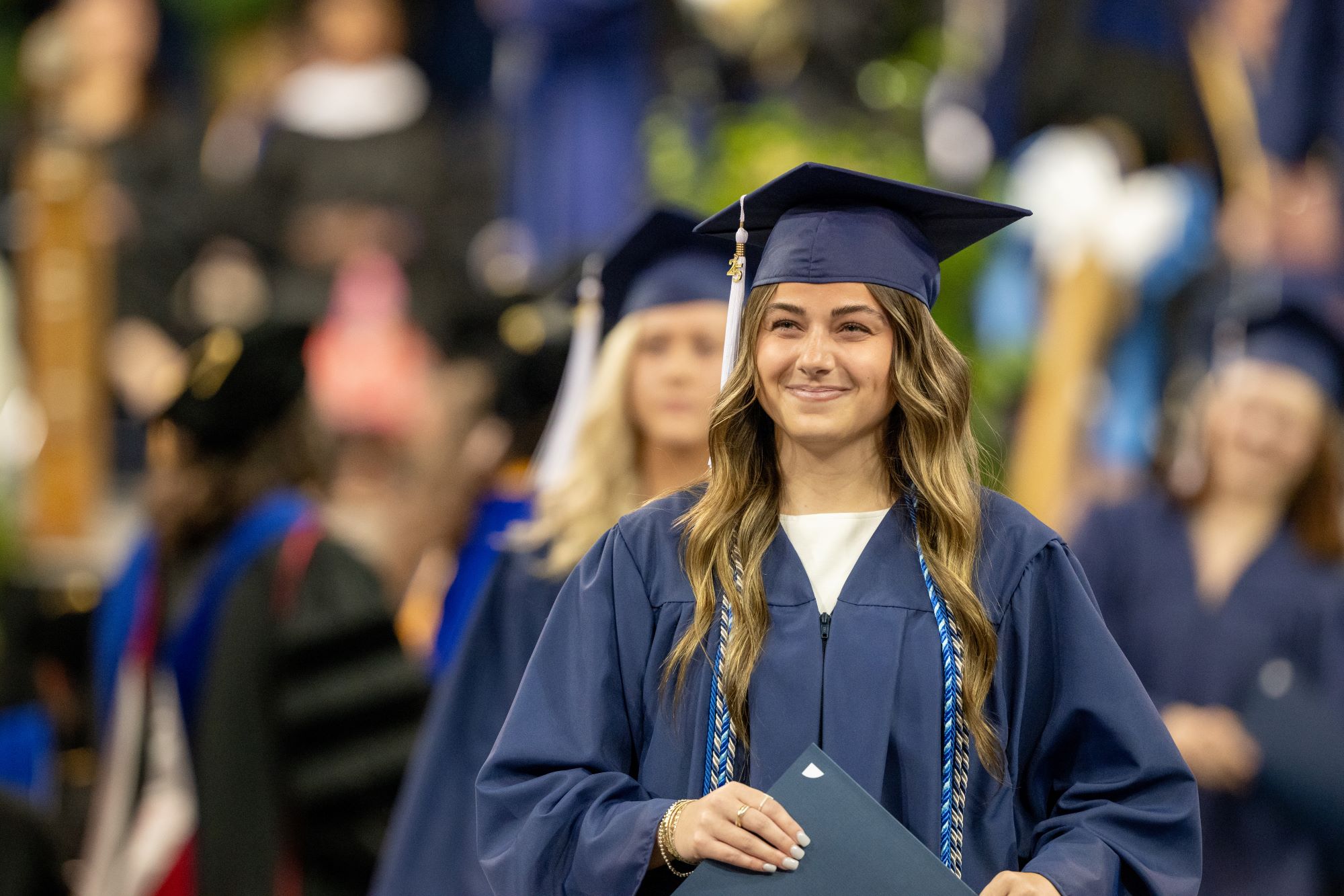 A Penn State Behrend graduate smiles after receiving her degree.