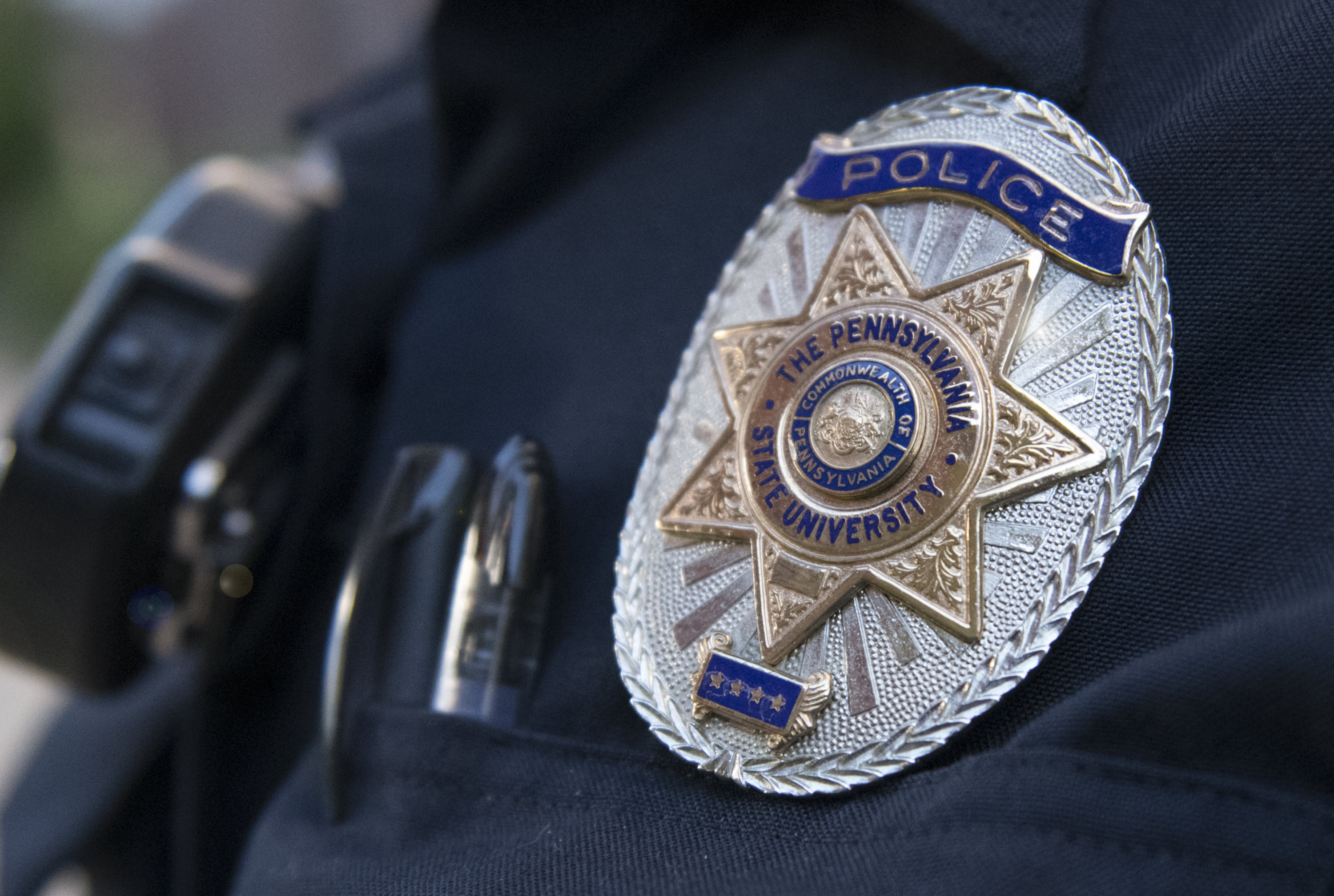 Police officer shoulder shown with metal badge on arm.