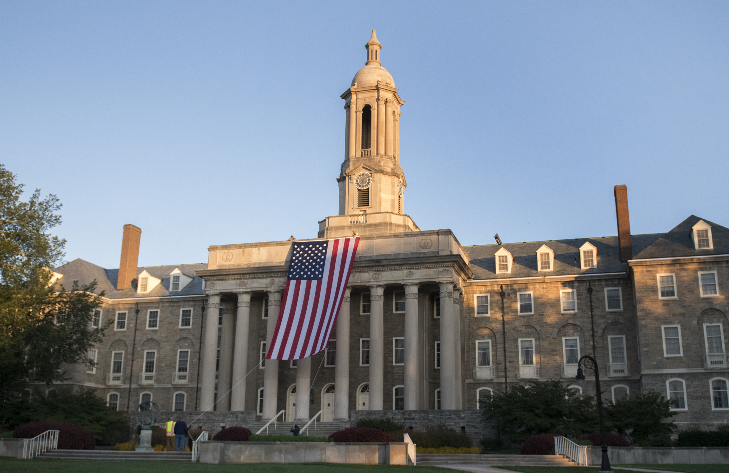 wide shot old main with flag