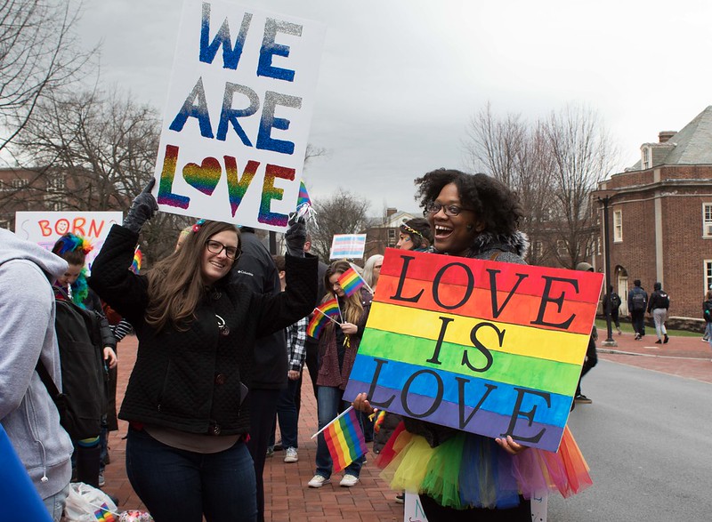 students holding signs depicting messages about love