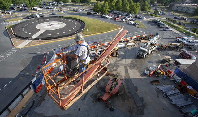 A man on construction equipment oversees construction on a medical center campus