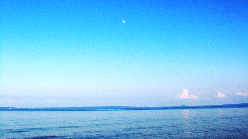 The moon shining over a body of water