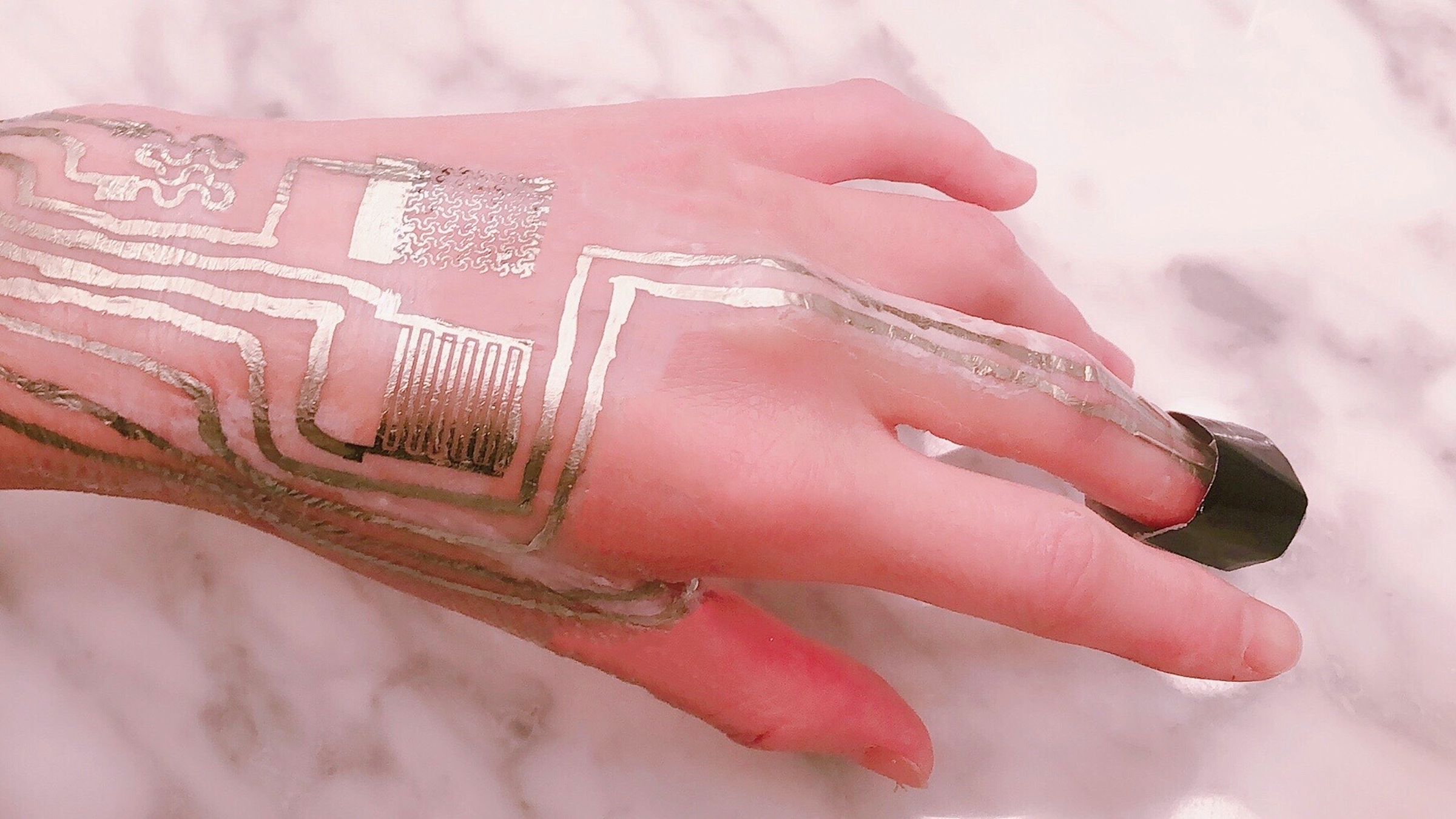 A hand with a gold sensor melded to it 