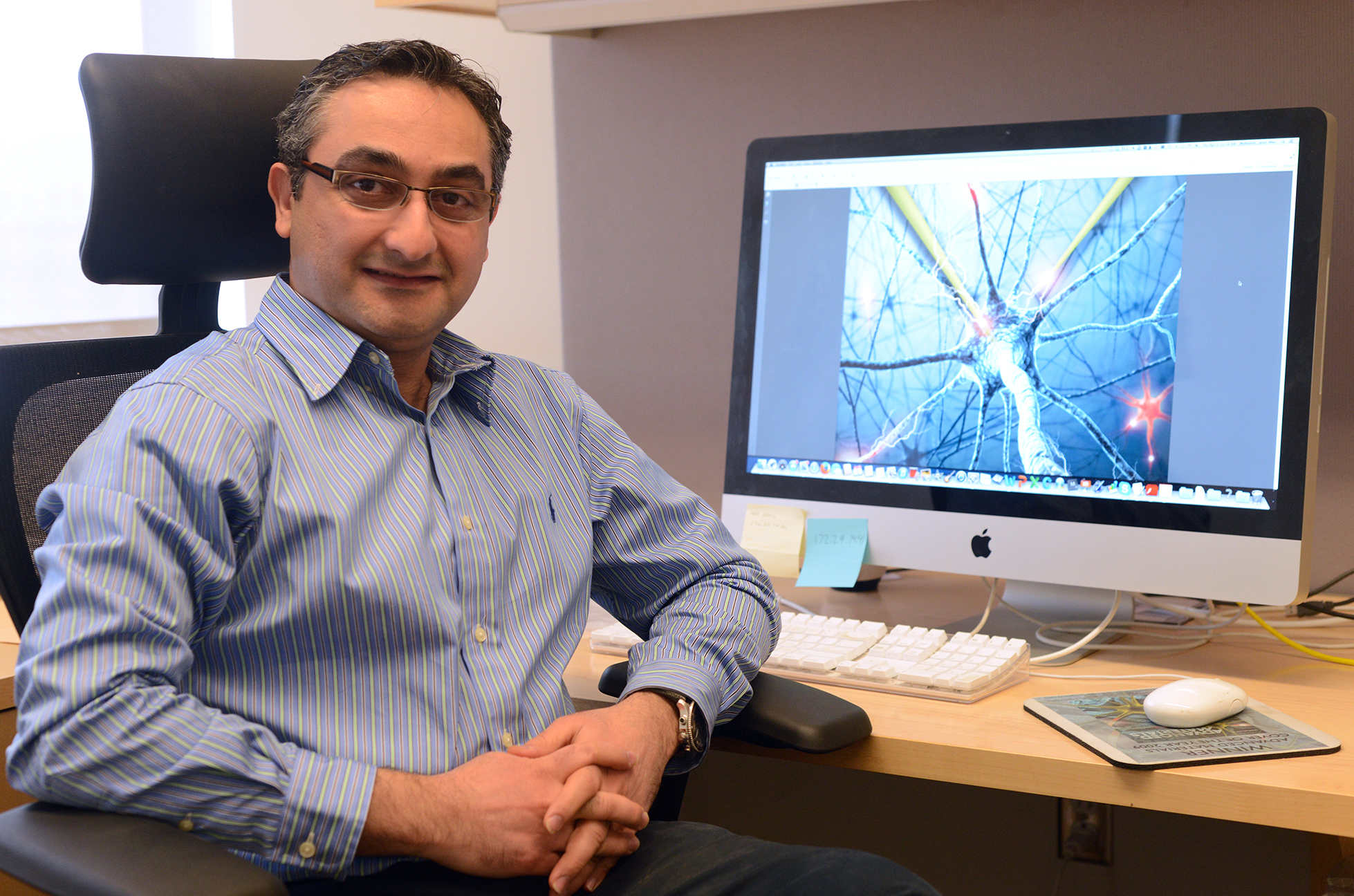 Mohammad Reza Abidian, professor of biomedical engineering, sitting at his desk