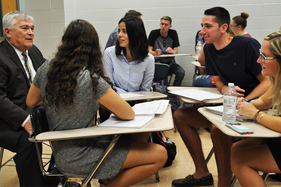 President Barron sits with a small group of students brainstorming ideas