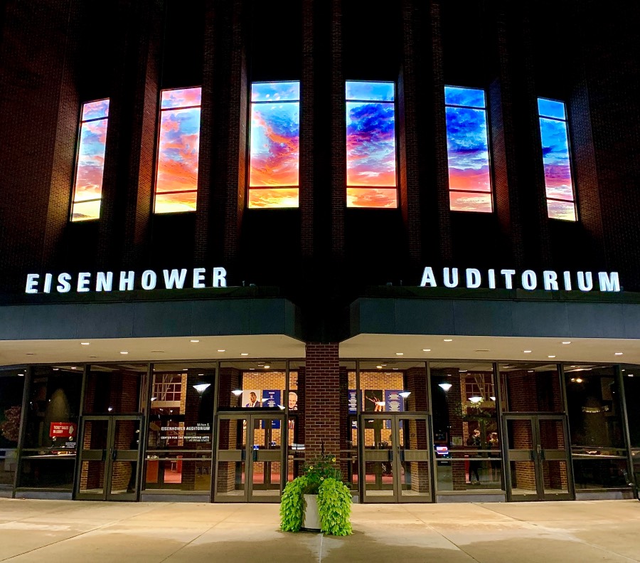 Imagery of a sunset is shown in the long, vertical windows of Eisenhower Auditorium.