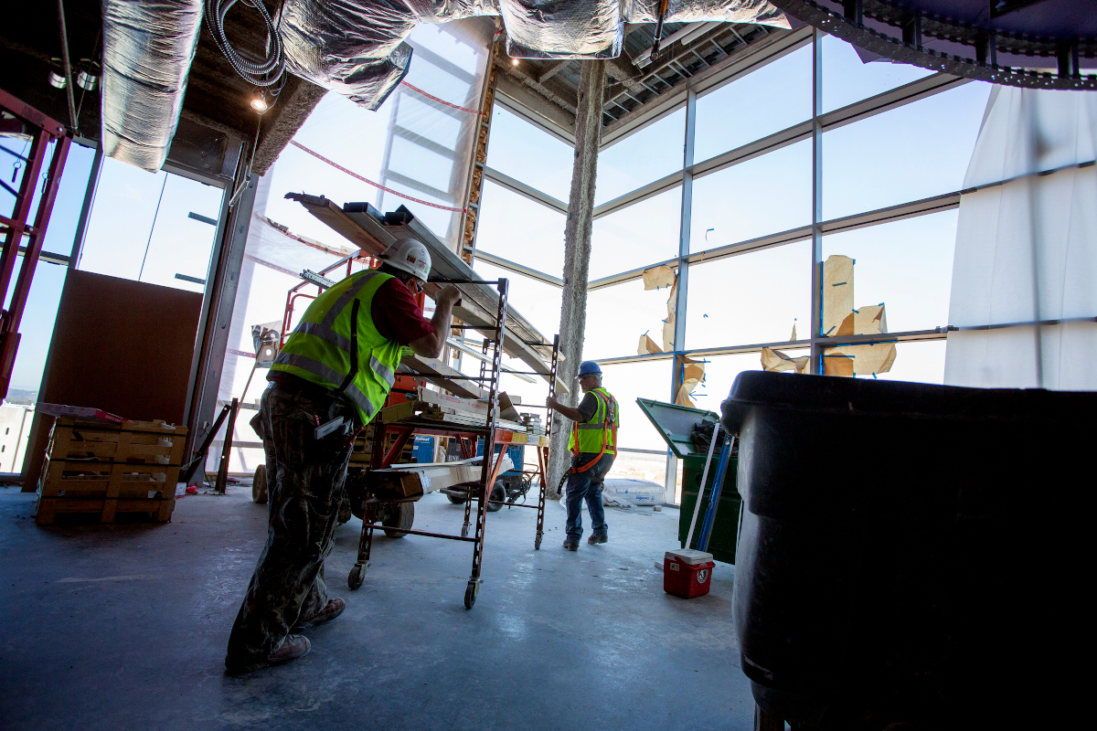 Construction workers work on the interior of a building