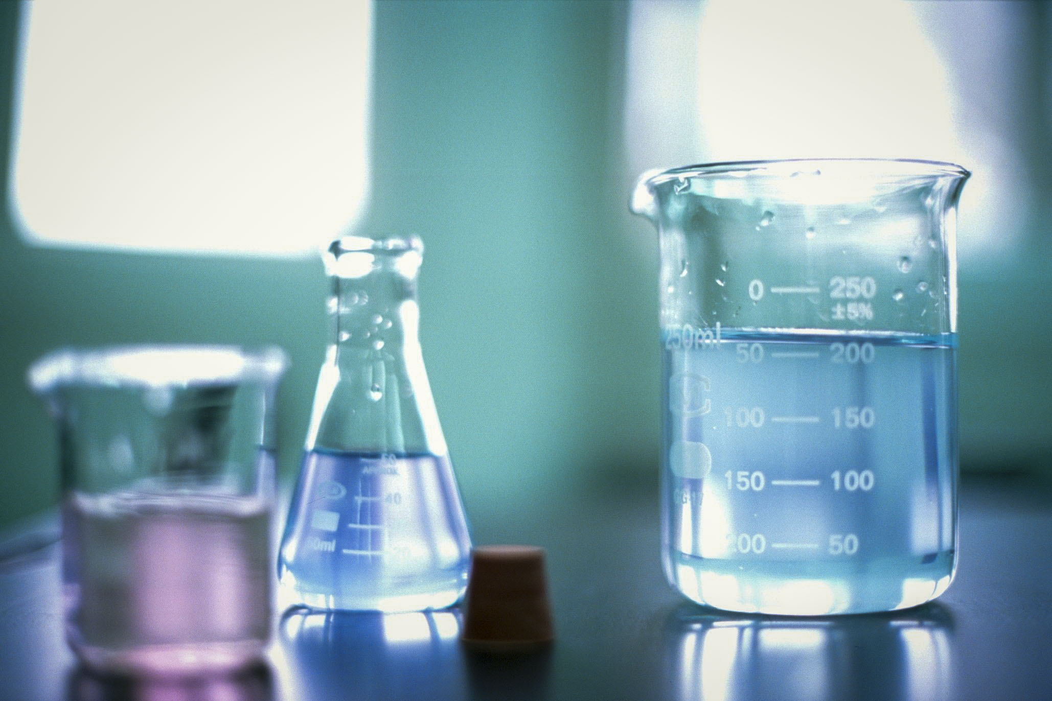 Three different chemistry beakers sitting on a table