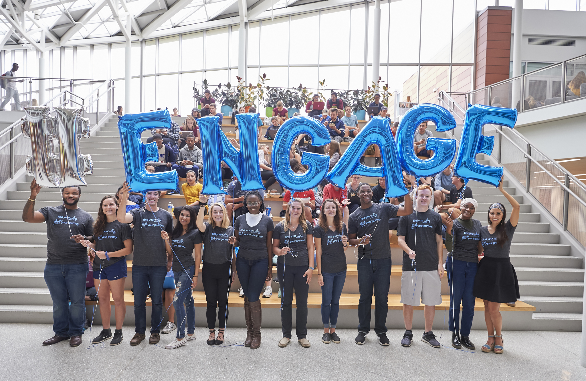 Students hold balloons spelling out the word engage