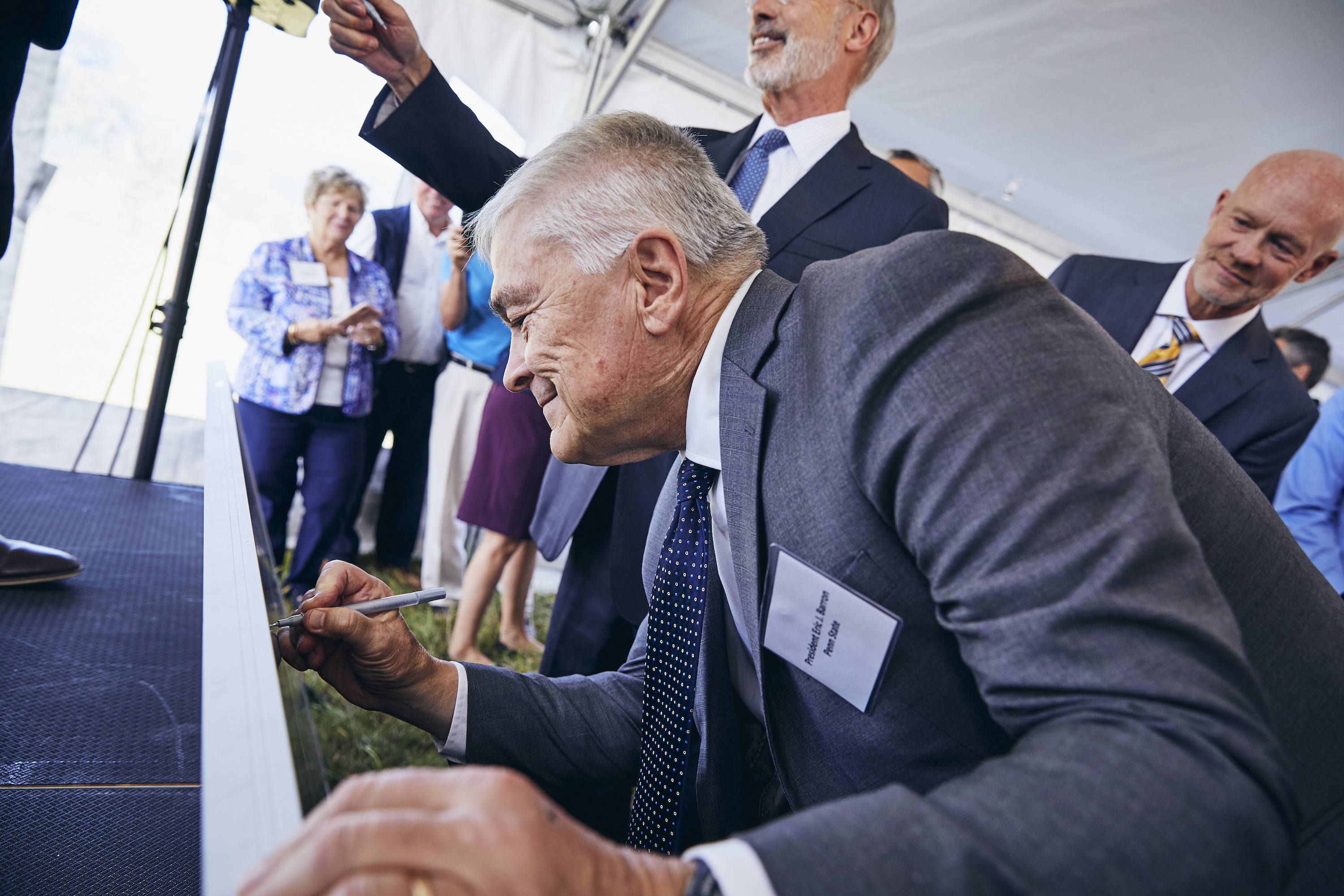 Penn State President Eric J. Barron signs a solar panel at the groundbreaking for a utility-scale solar project in Franklin County on Sept. 6, 2019.