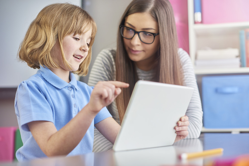 Teacher with student using ipad