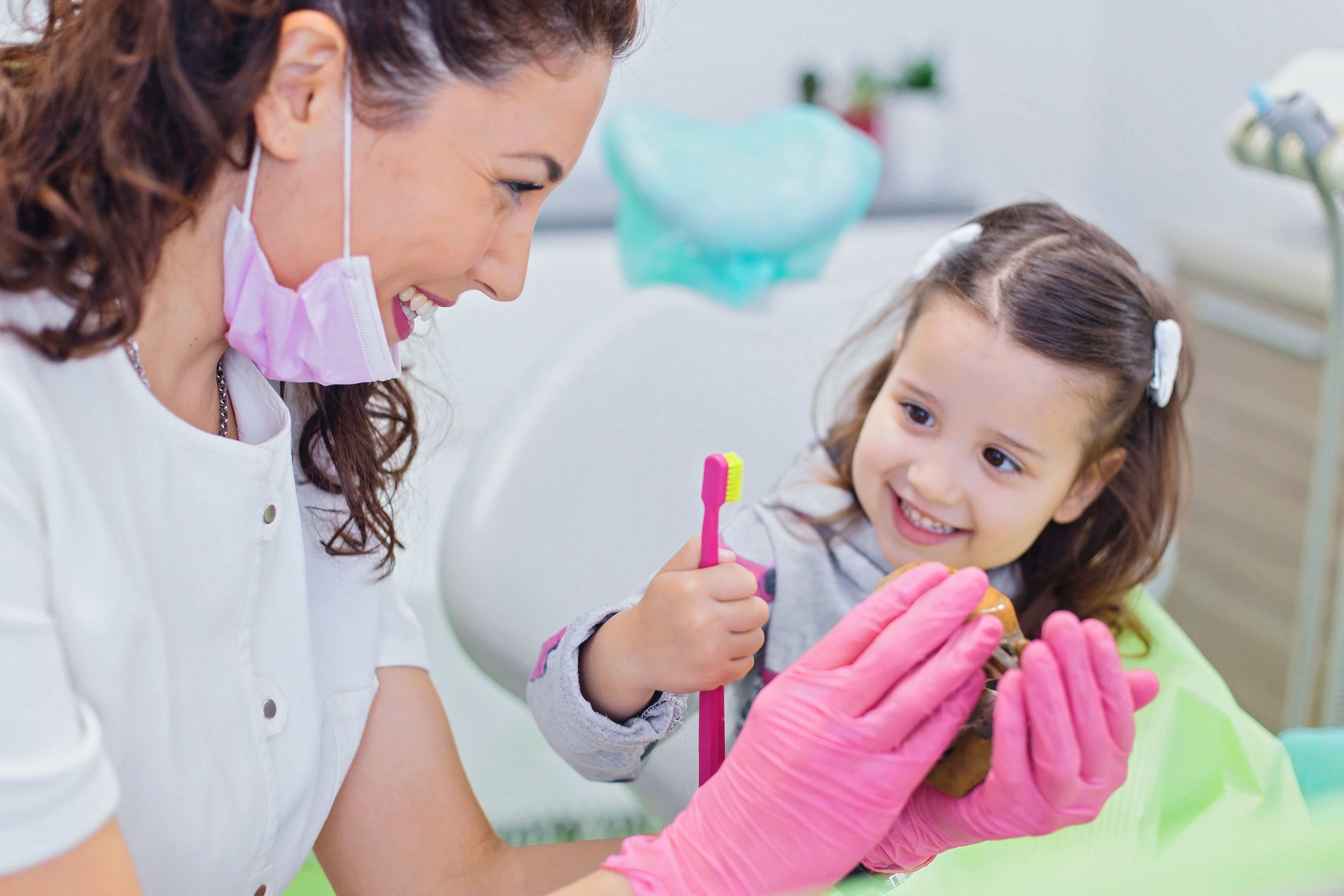 Child at the dentist holding toothbrush 