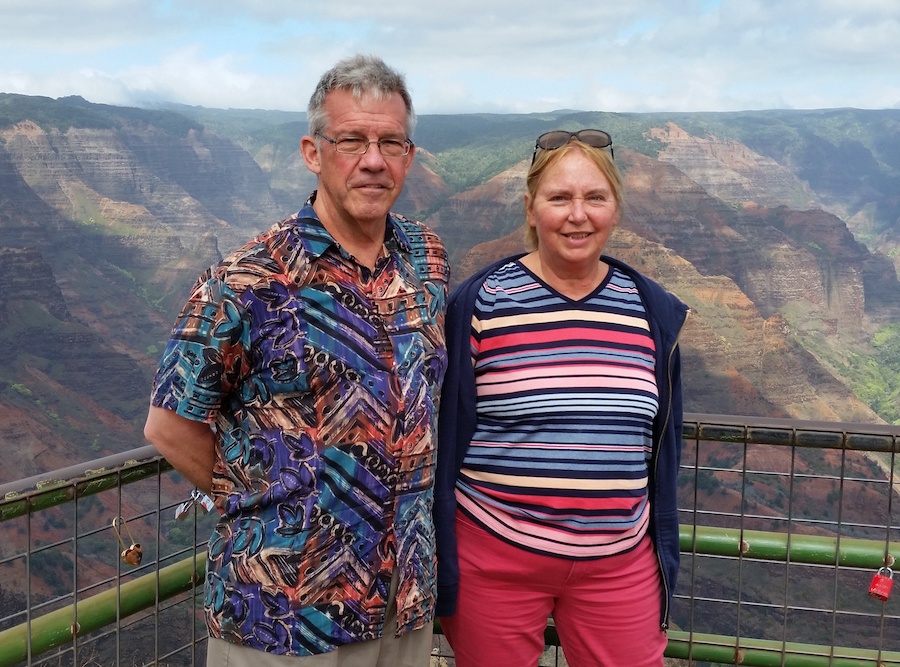 Joan and Ken Miller pose for a photo in front of an overlook in Hawaii