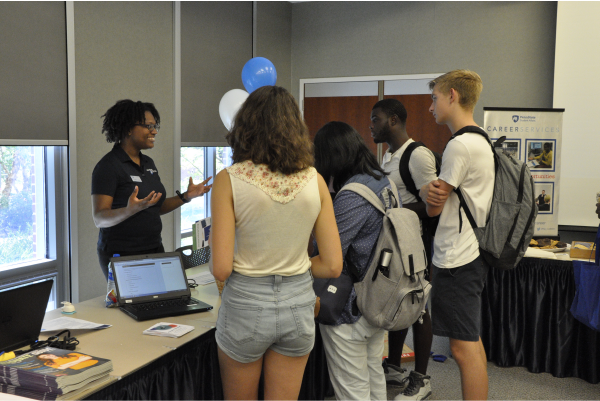 Shidika Goode, Resource Specialist, explains career resources to students during Career Services Open House