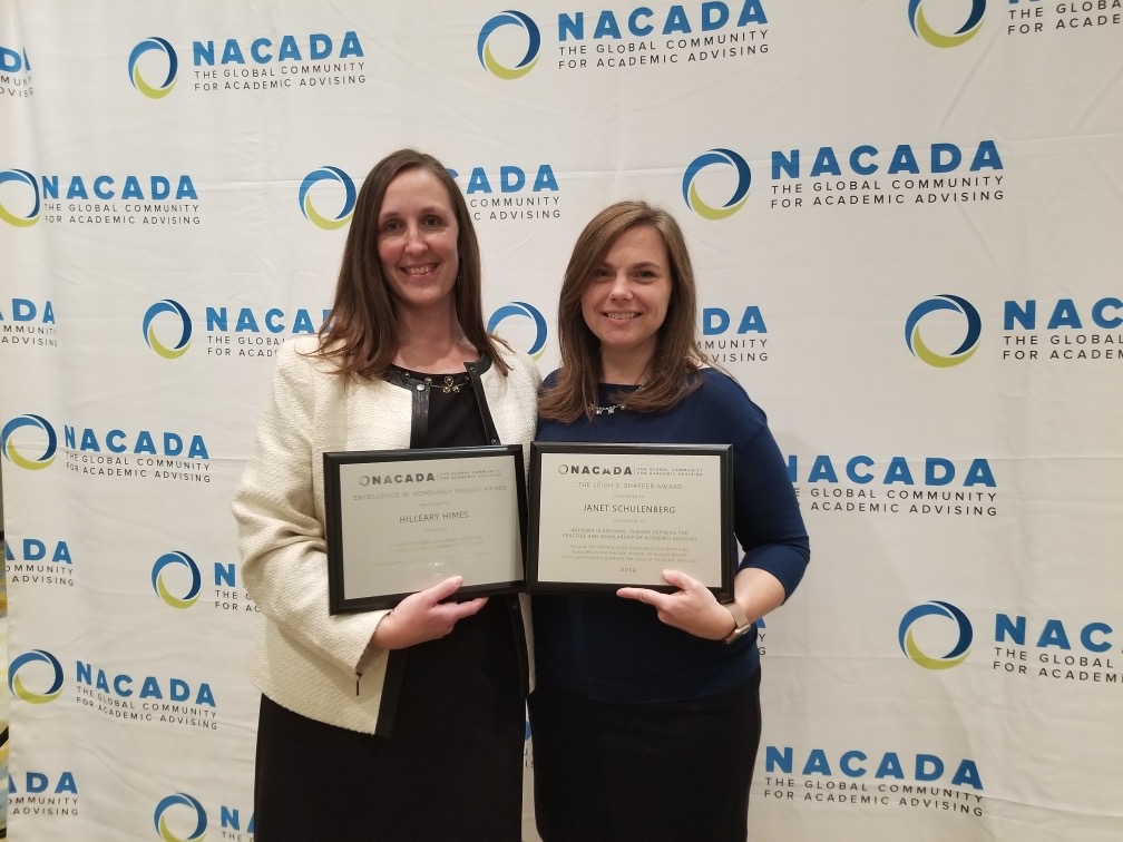 Hilleary Himes and Janet Schulenberg pose for a photograph holding their award plaques