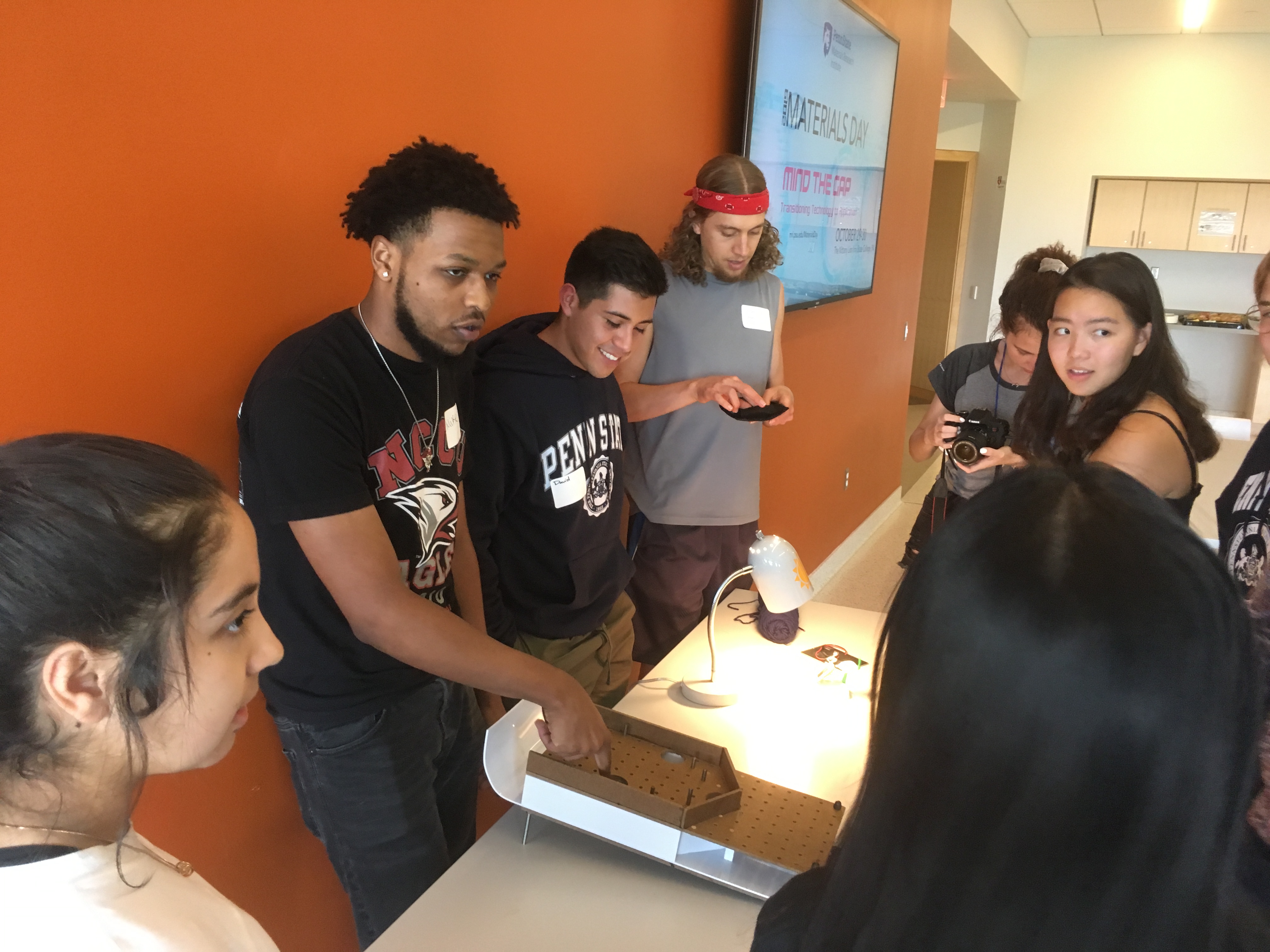 Group of students viewing a demonstration and discussing.