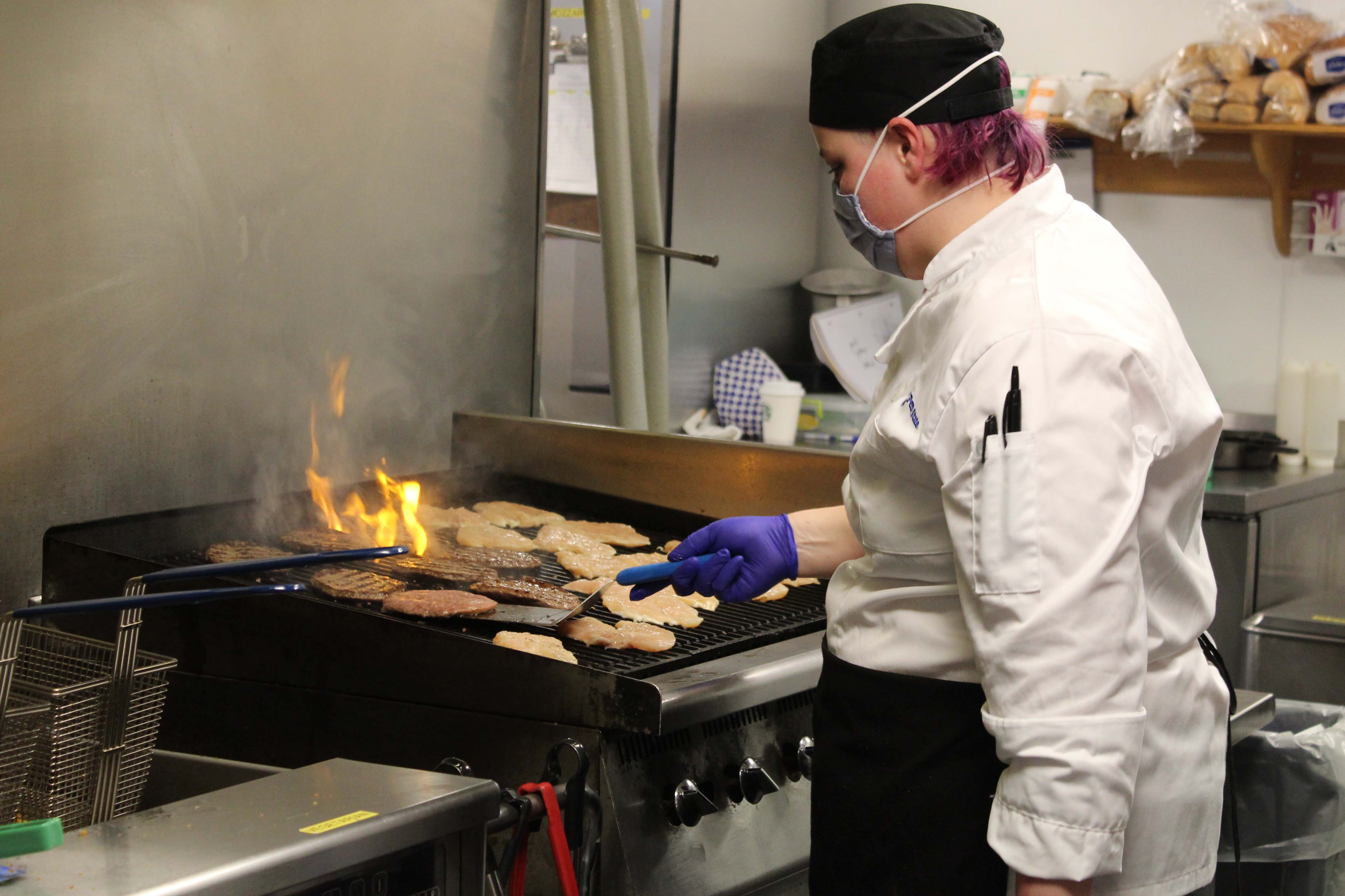 Sarah Graham, food preparer, grills up delicious chicken and burgers at the new Market North in Warnock Commons [nid: 648042]