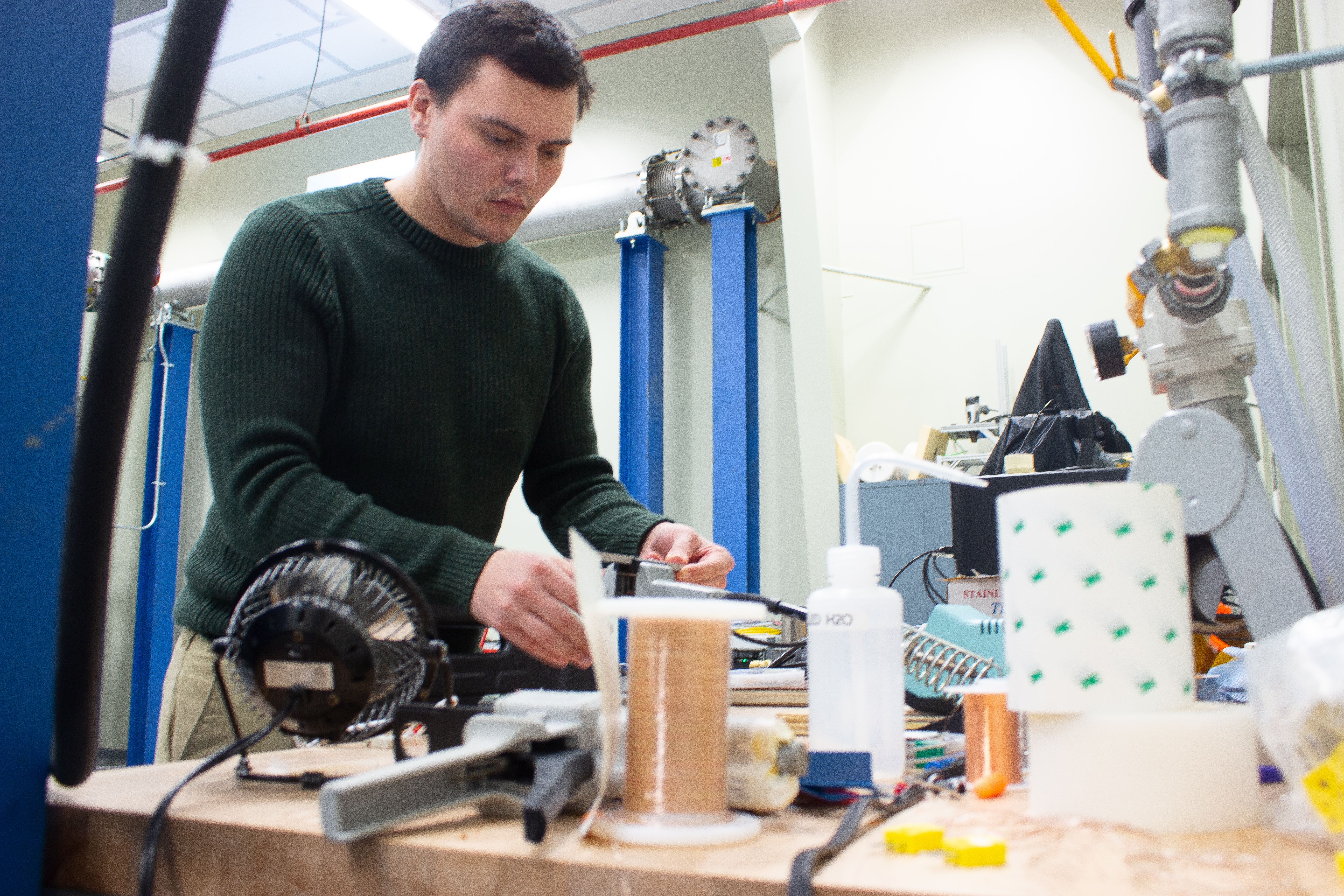 A Caucasian man works with gas turbine components in a lab.