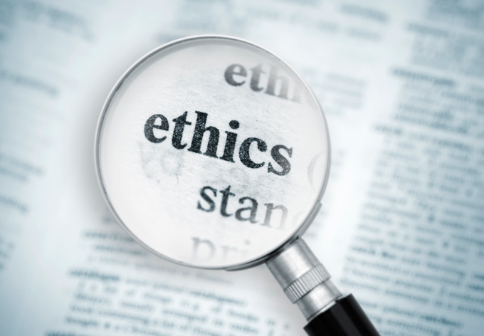 The word ethics enlarged by a magnifying glass.