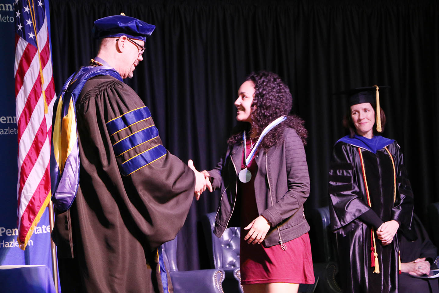 Student receives medal from chancellor at Academic Achievement Awards ceremony. 