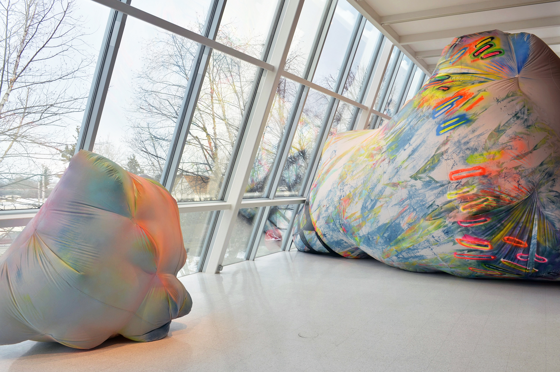 Large, colorful inflatable rocks in a gallery