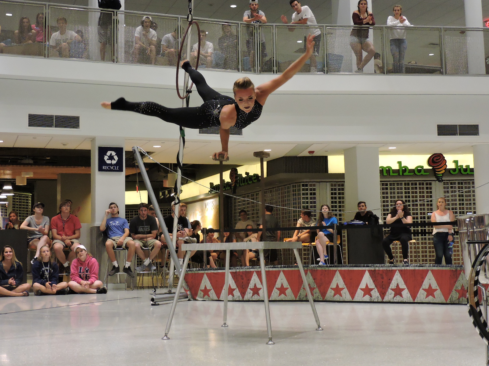 Acrobat balances on a stick with one arm