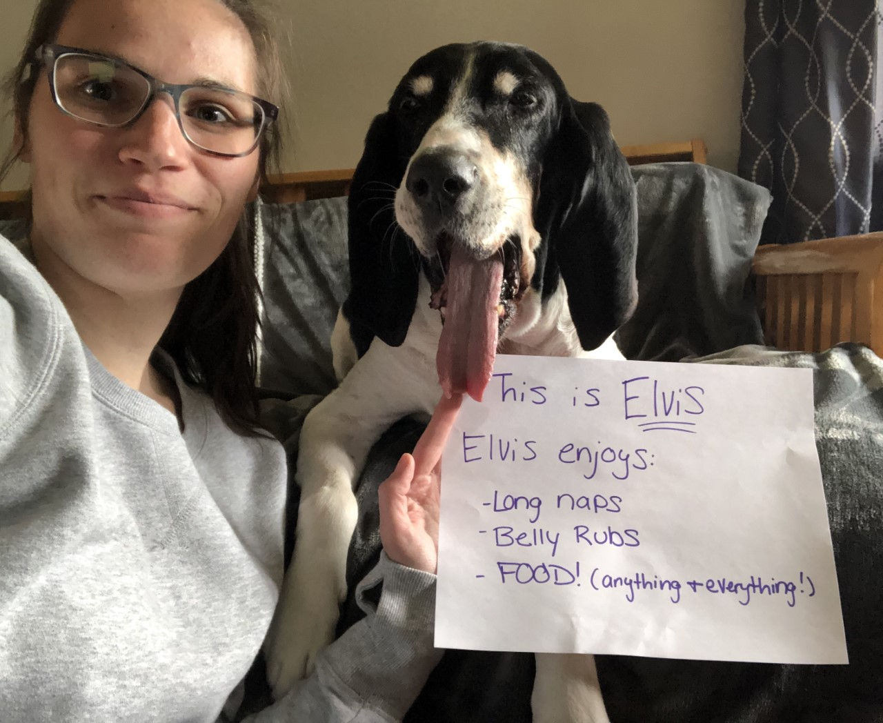 Student with her dog holding handwritten sign