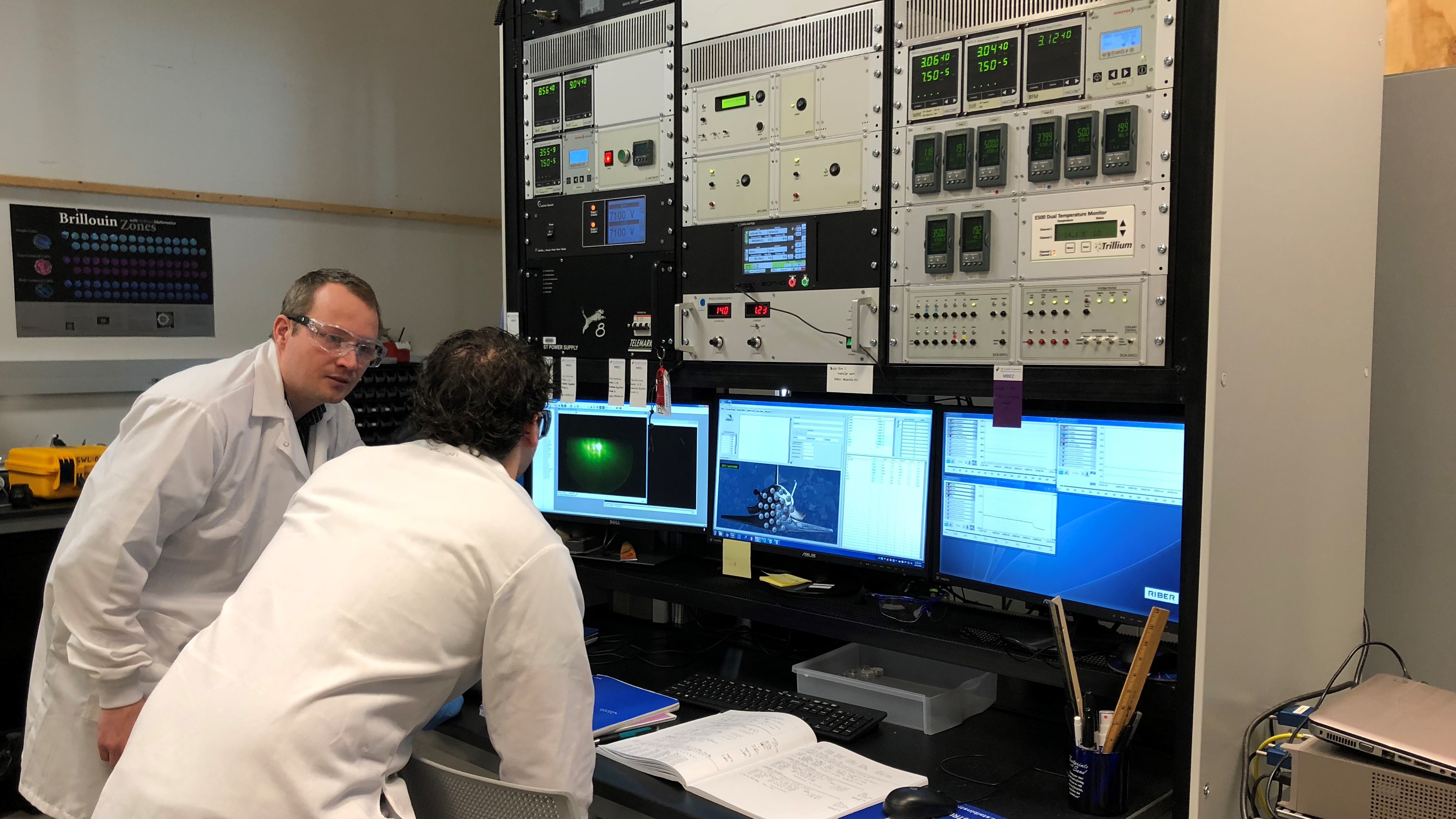 Two men reviewing information on computer screen