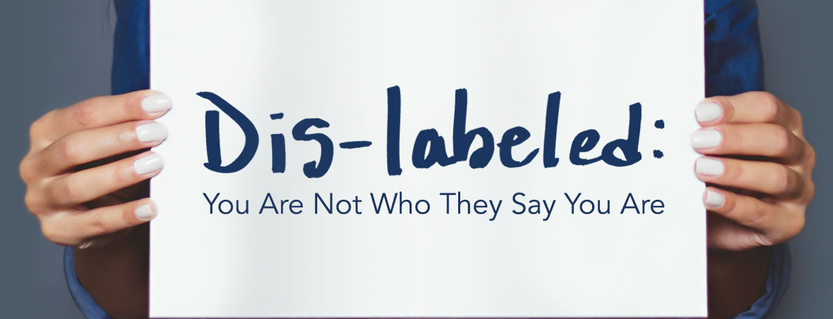 Person holding sign that says: Dis-labeled: You are not who they say you are