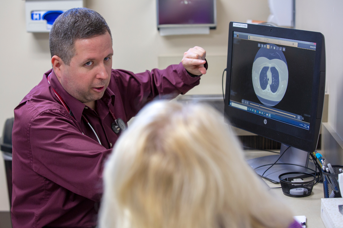 A doctor talks with a patient about a pulmonary image