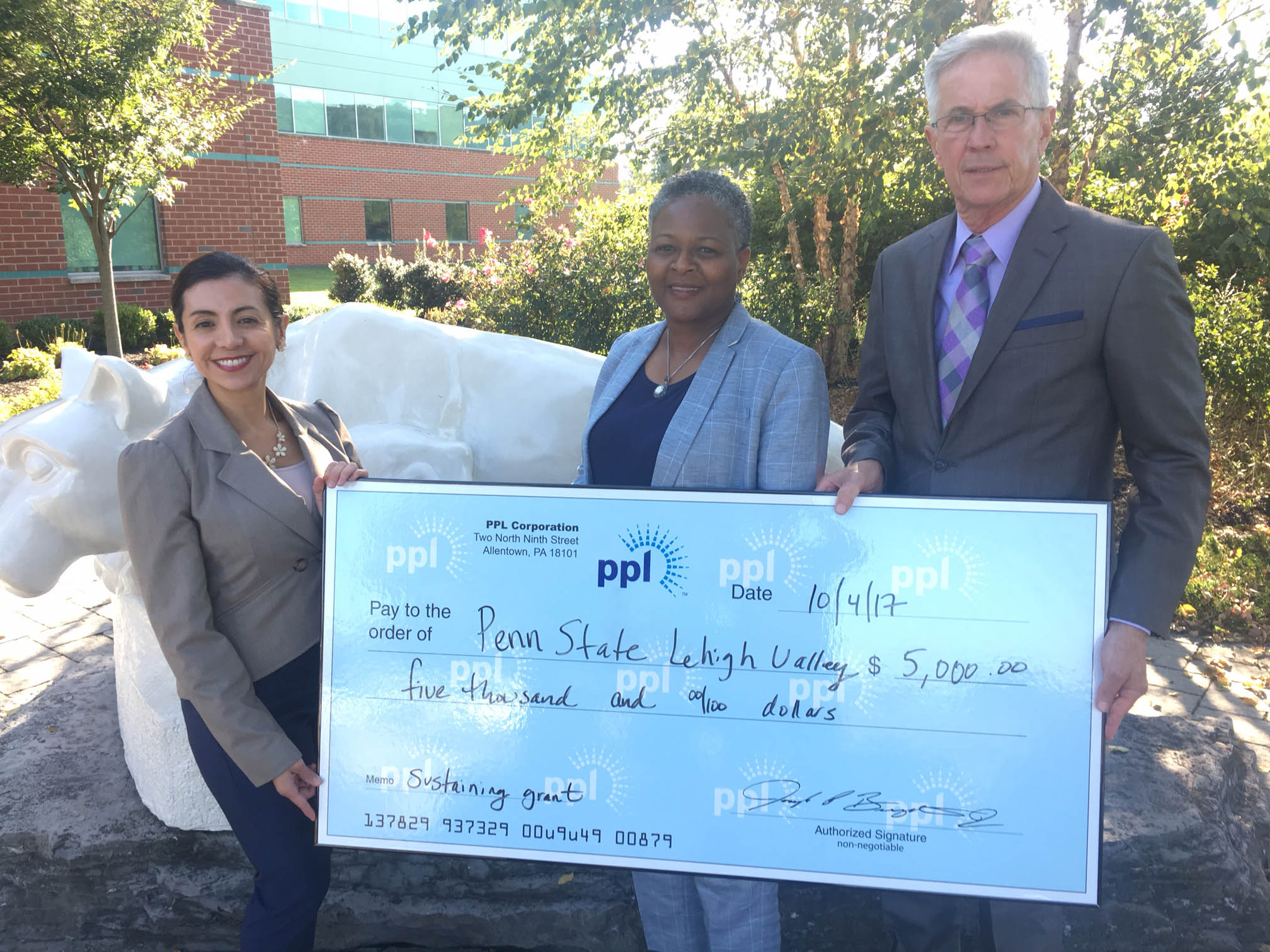 three people posing with check