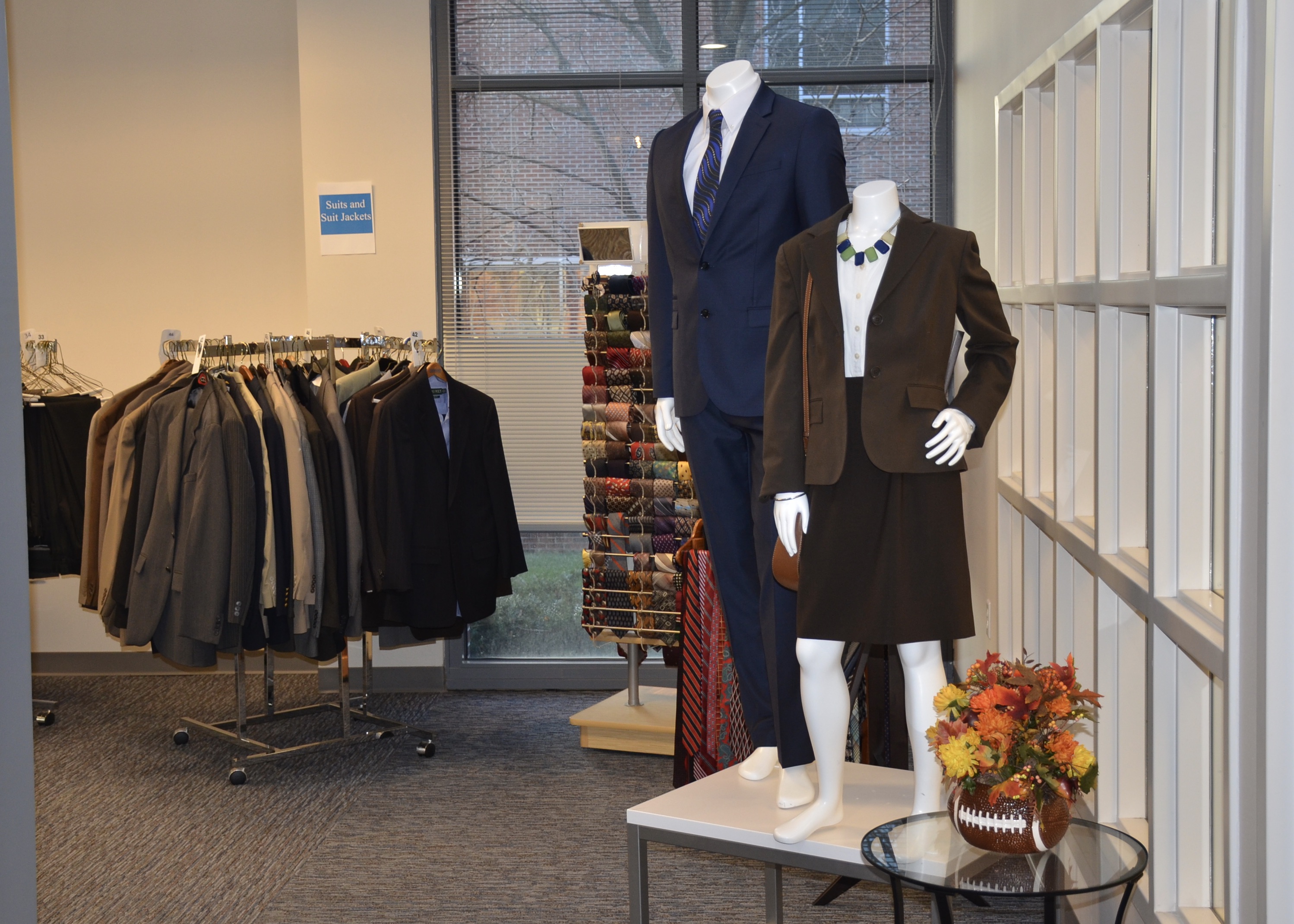 clothing rack with suit jackets and models wearing suits