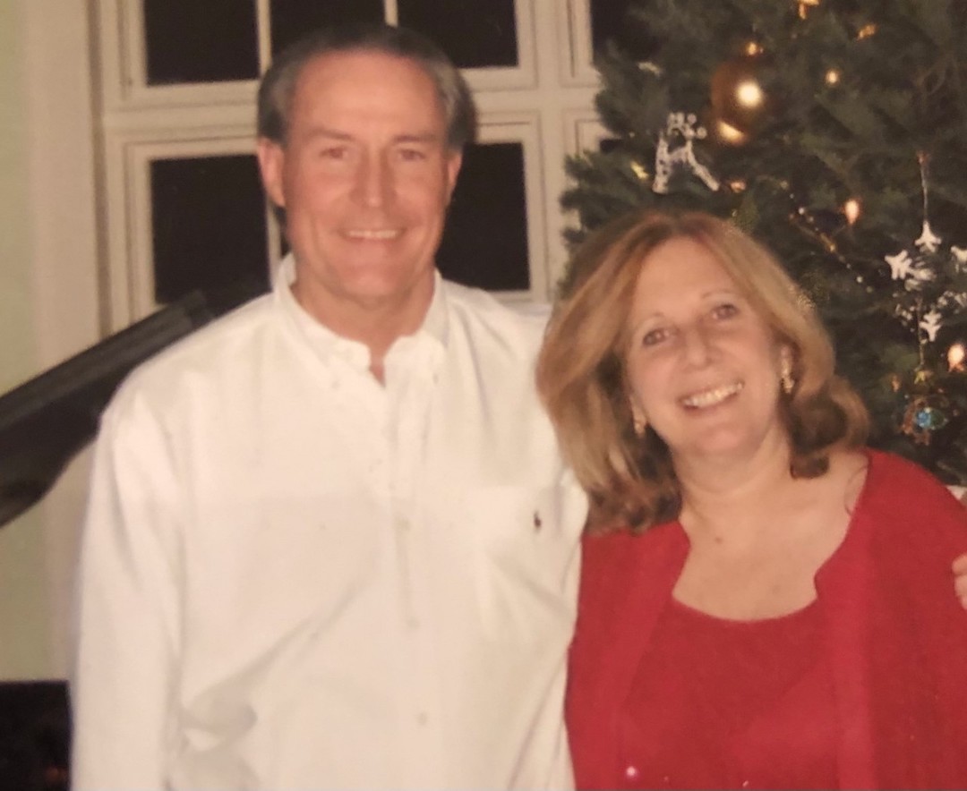 Bob and Denise Rohrbach in front of Christmas tree.