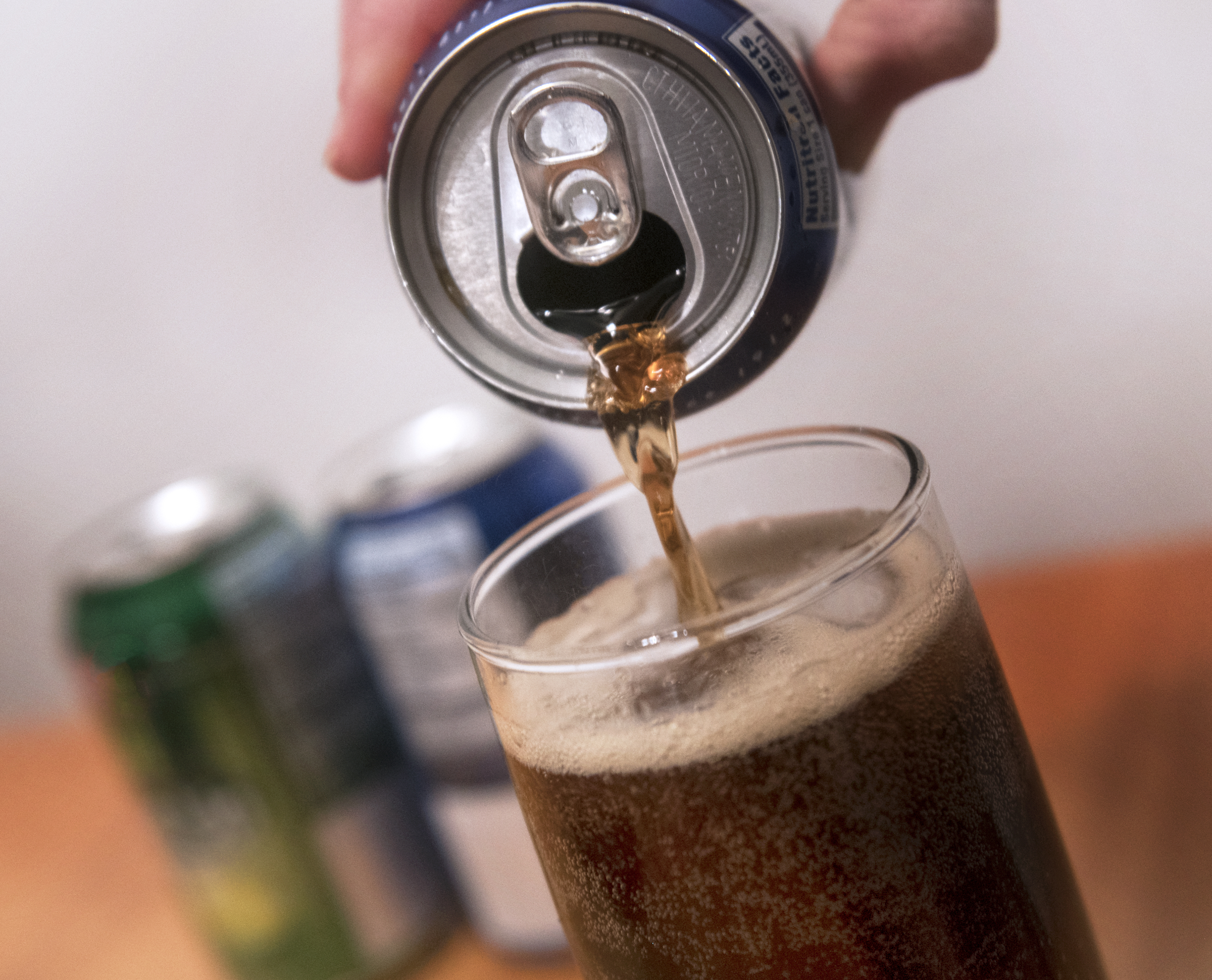 Close up of a can of soda being poured into a glass