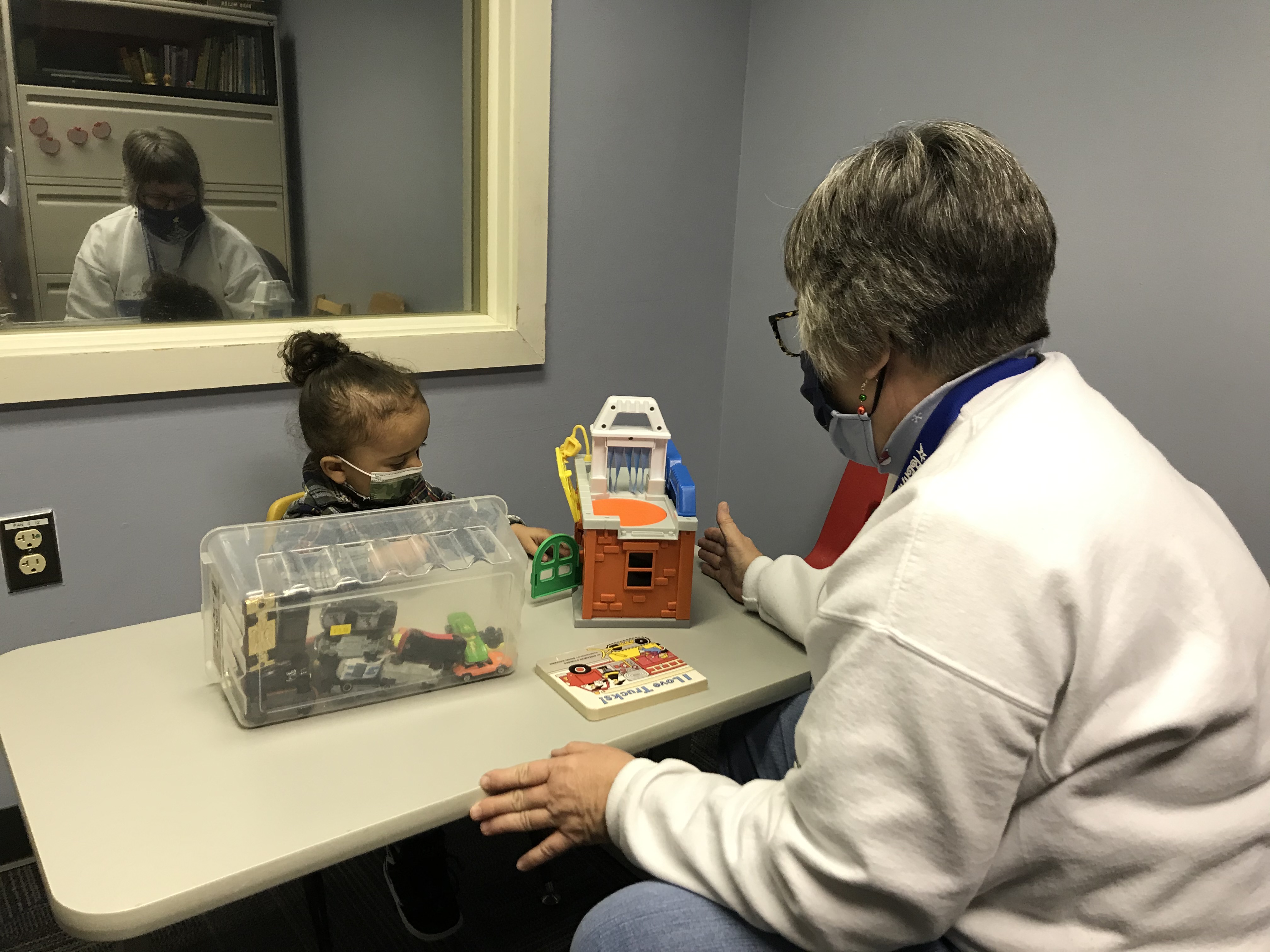 A speech-language pathologist meets with her young client